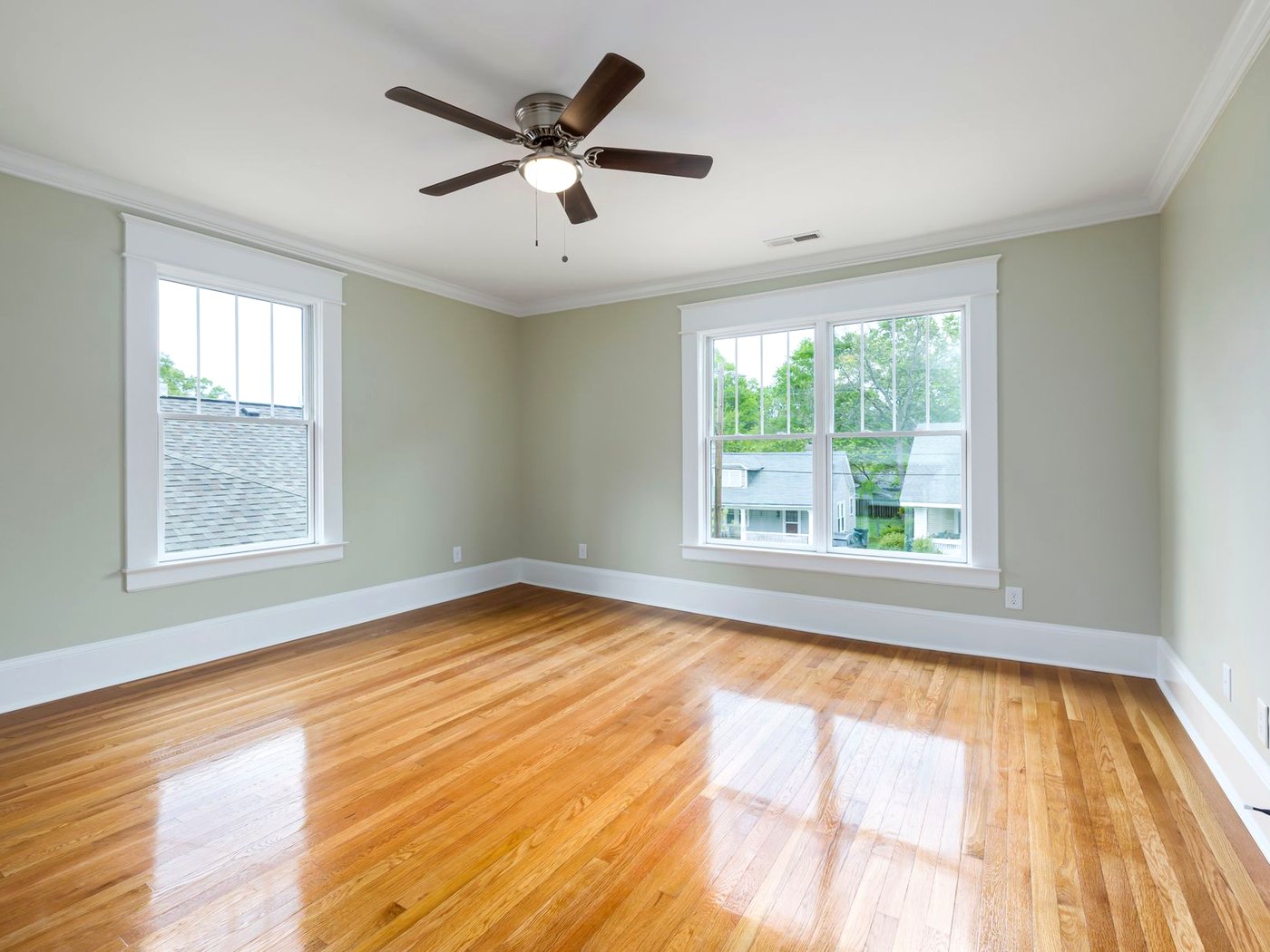 A ceiling fan and light fixture in a clean, bright room