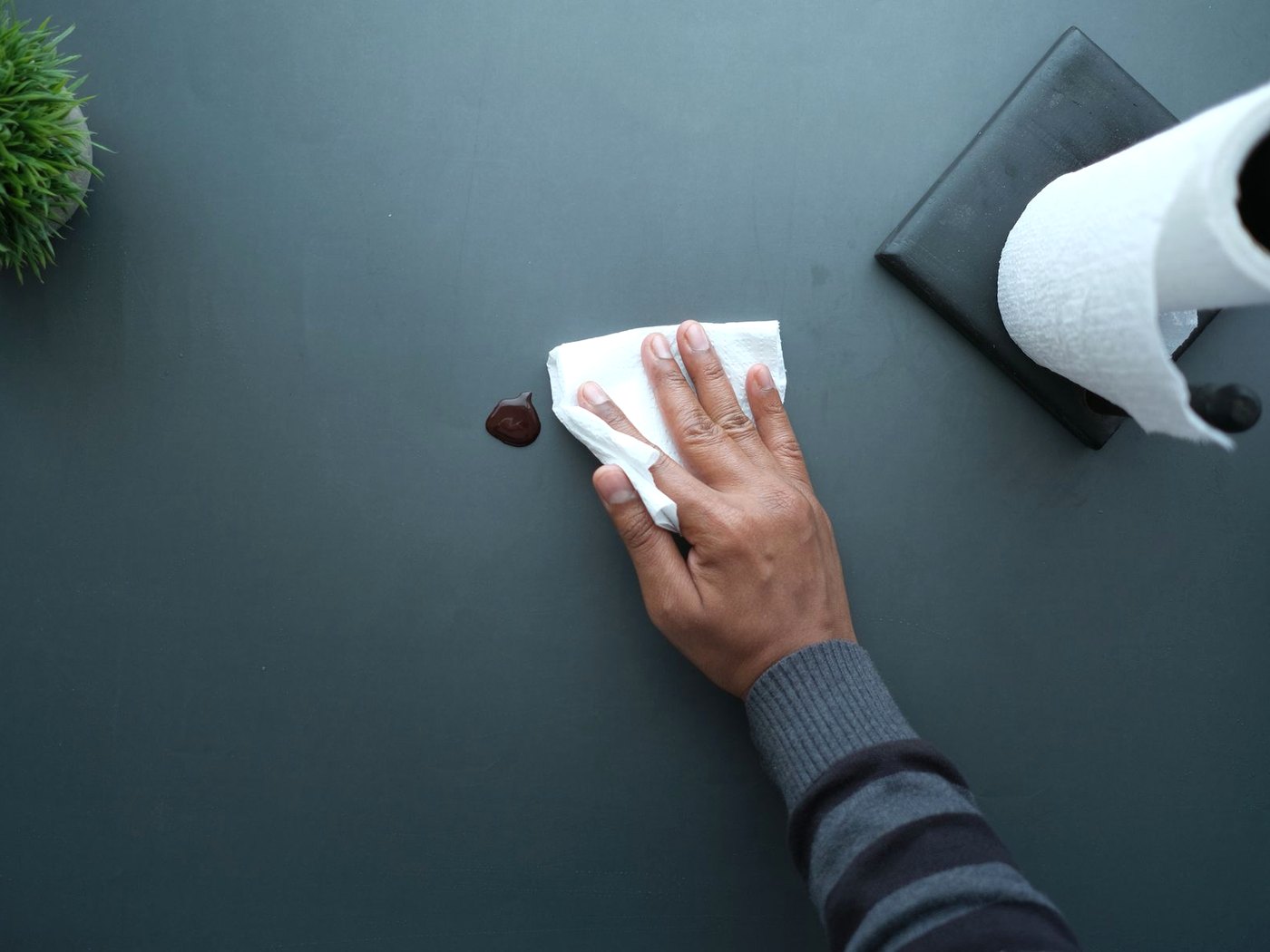 A hand wiping a light switch and wall plate