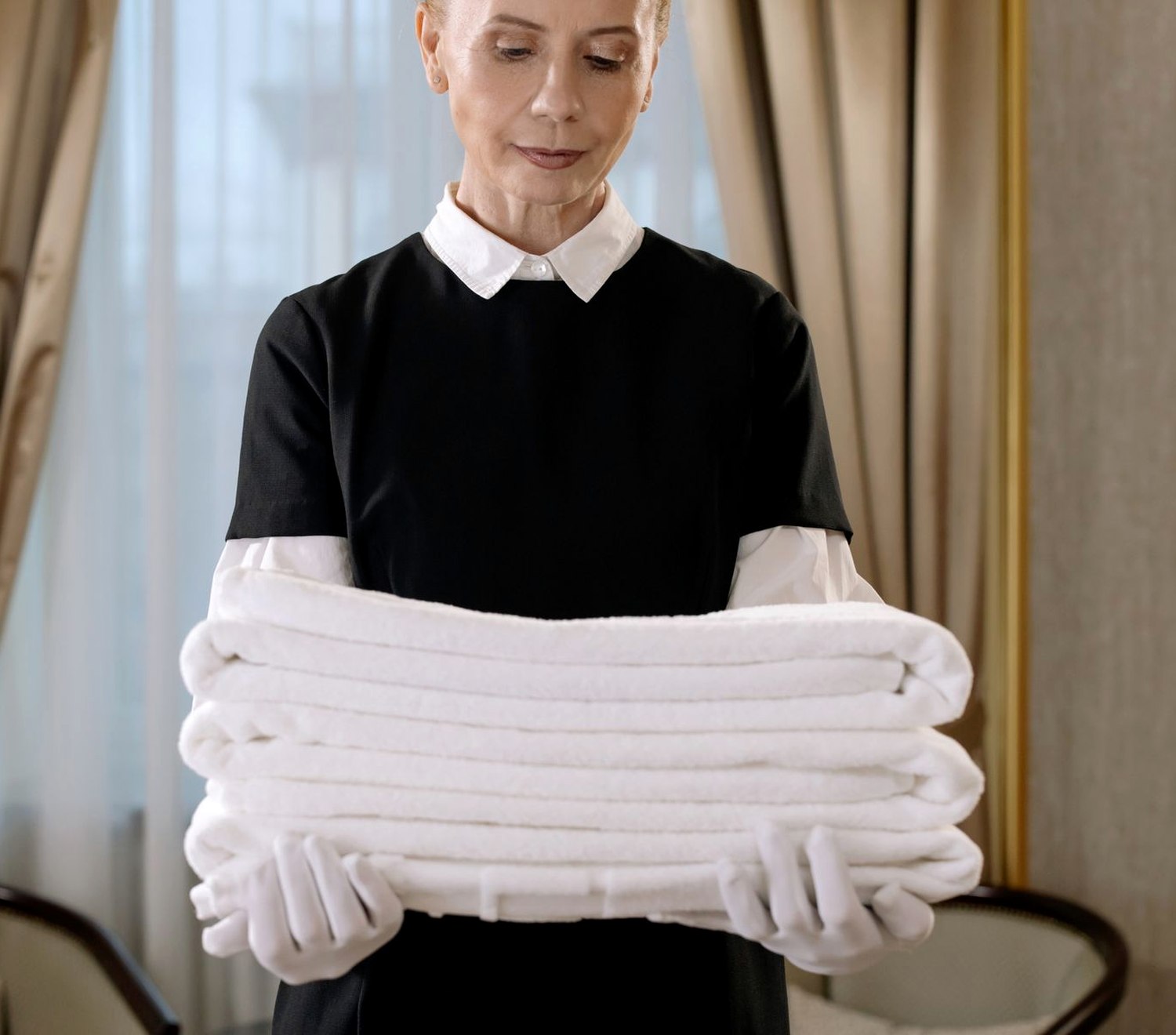 Housekeeping staff carrying a stack of crisp folded white linen, the hotel standard East Cleaning works to