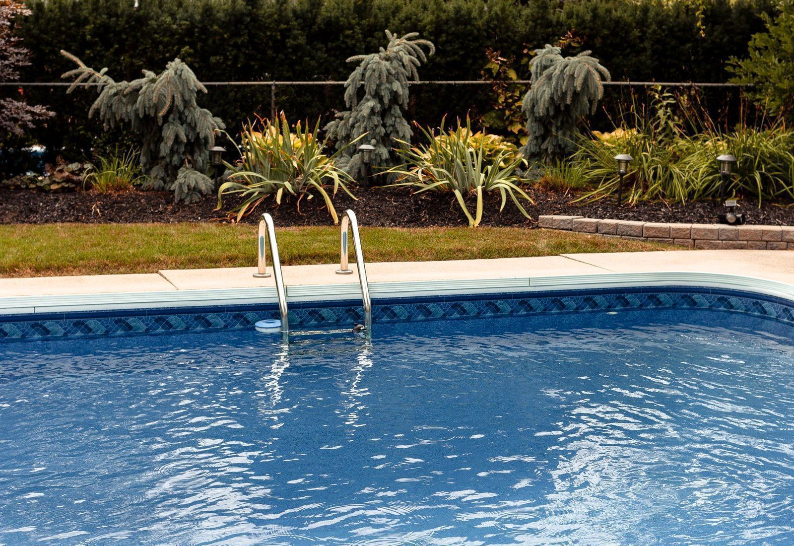 A backyard pool and deck ready for guests